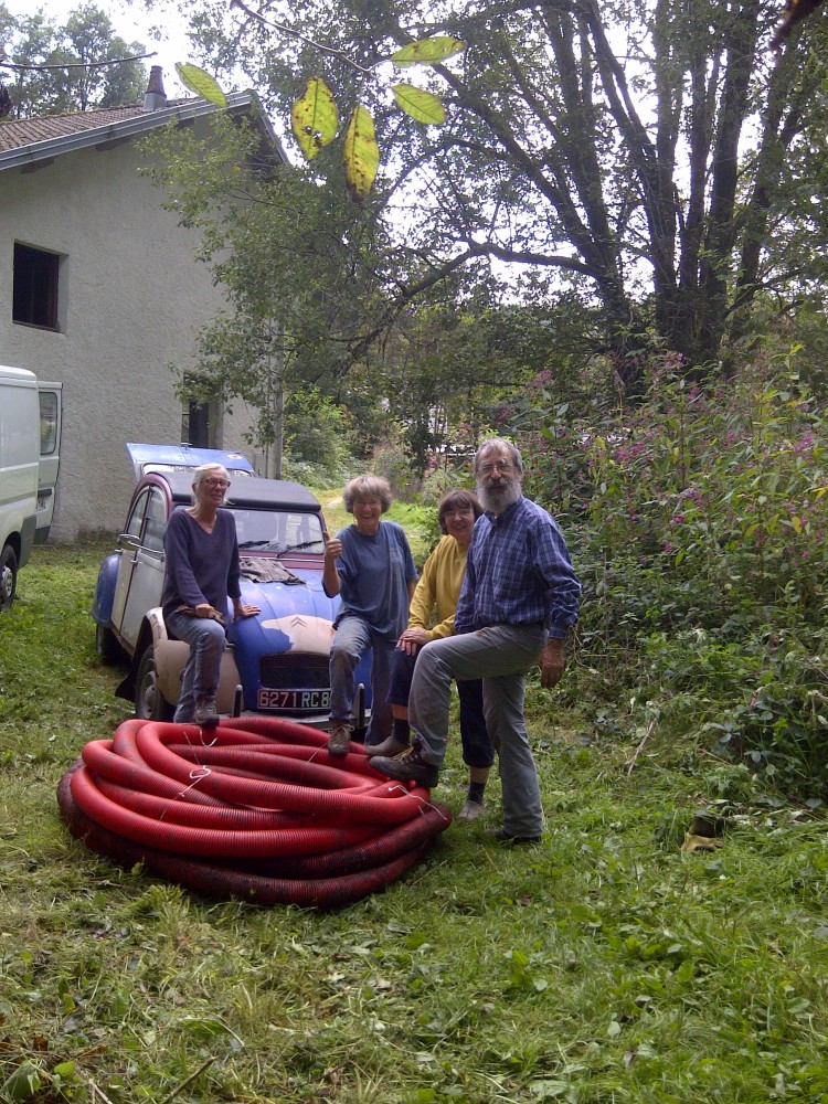 Chantier participatif à la scierie d'Avin. 4 participants photographiés la 2 CV.