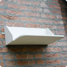 Planchette contre les fientes d'hirondelles accrochée à un mur.