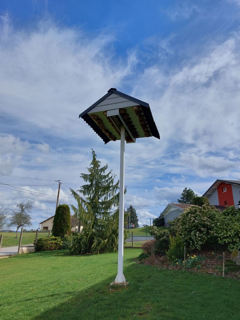 Tour à hirondelles sur un mas métallique avec pied en béton installée ans un jardin privé.