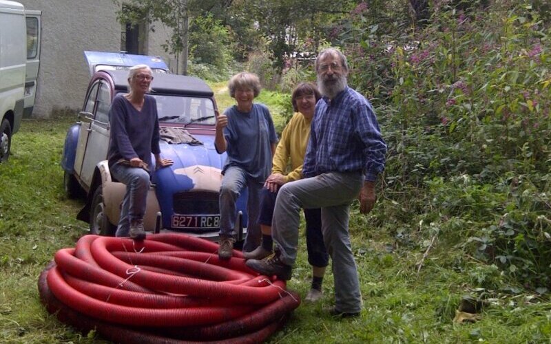 4 participants à un chantier à la maison d'Oiseaux-Nature photographiés devant une 2CV.